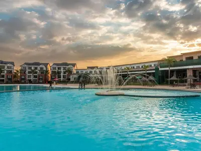 a swimming pool with a fountain in front of buildings at The Blyde - Posh Living in Pretoria