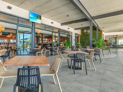 a restaurant with tables and chairs and windows at The Blyde - Posh Living in Pretoria