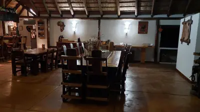 a dining room with a long table and chairs at Berchtesgaden Game Ranch & Lifestyle Farm in Vaalwater