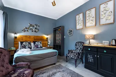 a bedroom with a bed and a desk and chairs at Rozelee Rest 1 in Nelspruit