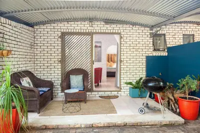 a patio with two chairs and a grill at Rozelee Rest 1 in Nelspruit