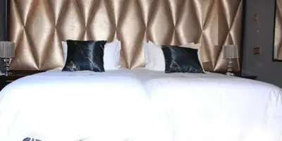 a bed with two black pillows on top of it at Thavhani boutique hotel in Thohoyandou