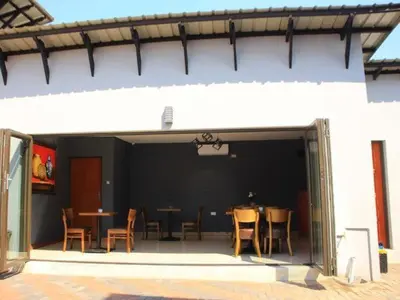 a patio with tables and chairs in a building at Thavhani boutique hotel in Thohoyandou