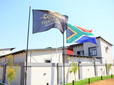 a flag and a rainbow flag in front of a building at Thavhani boutique hotel in Thohoyandou