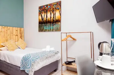 a bedroom with a bed and a painting on the wall at Rozelee Rest in Nelspruit
