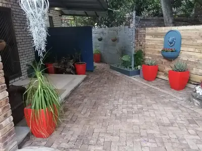 a patio with potted plants in red pots at Rozelee Rest in Nelspruit