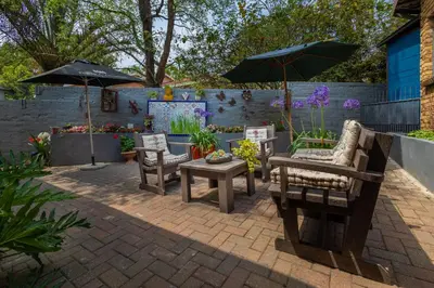 a patio with chairs and tables and umbrellas at Rozelee Rest in Nelspruit