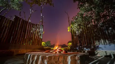a table with a fire in front of a fence at Kilima Private Game Reserve & Spa in Gravelotte