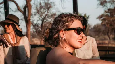 a woman wearing sunglasses sitting on a bus at Kilima Private Game Reserve & Spa in Gravelotte