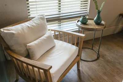 a chair with a pillow sitting next to a table at Buccara Waterberg - Molapo in Lephalale