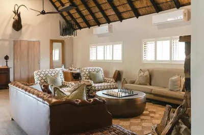 a living room with a couch and a table at Buccara Waterberg - Molapo in Lephalale