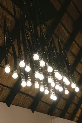 a bunch of lights hanging from a ceiling at Buccara Waterberg - Molapo in Lephalale