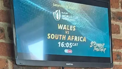 a television mounted on a brick wall with a sign at 712@Rest in Dullstroom