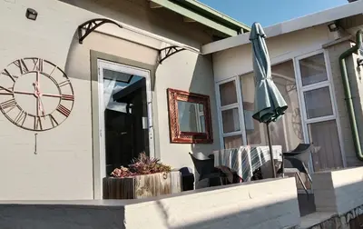 a clock and an umbrella on the side of a house at 712@Rest in Dullstroom