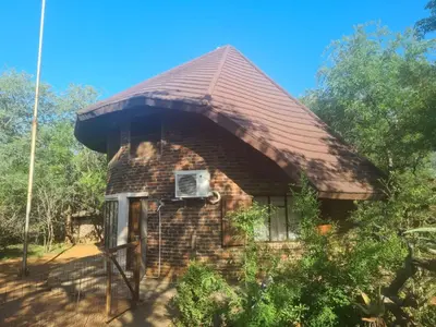 a small brick house with a roof at Chip n Debs Kruger Vacations in Marloth Park