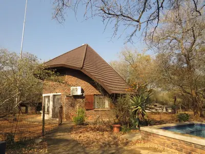 a small brick house with a pitched roof at Chip n Debs Kruger Vacations in Marloth Park