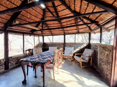a dining room with a table and chairs in a pavilion at Chip n Debs Kruger Vacations in Marloth Park