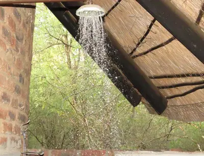 a shower with water coming out of a ceiling at Chip n Debs Kruger Vacations in Marloth Park