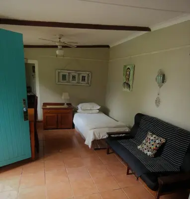 a bedroom with a bed and a couch at Fountain Baths Guest Cottages in Barberton