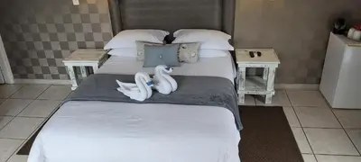 a bedroom with two beds with towels on the bed at Rockview Lodge in Nelspruit