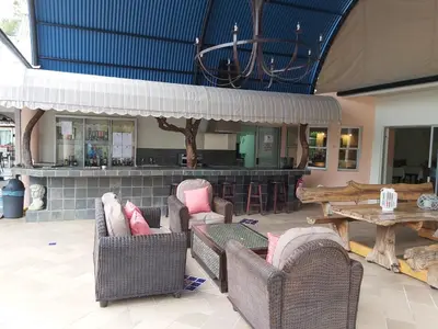 a room with chairs and a bar with a table at Rockview Lodge in Nelspruit