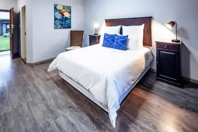 a bedroom with a large white bed with blue pillows at Olden Rose Place in Lephalale