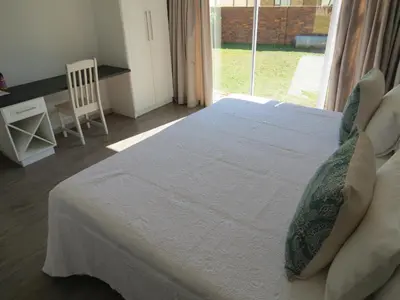 a bedroom with a white bed and a window at Olden Rose Place in Lephalale