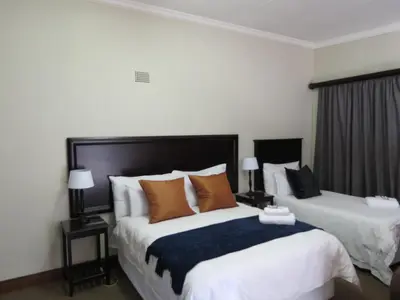 a hotel room with two beds with pillows at Olden Rose Place in Lephalale