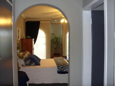 a bedroom with a bed and an arched doorway at Little Umhlanga. Sunflower suite. in Pretoria