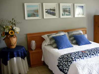 a bedroom with a bed with a vase of flowers on it at Little Umhlanga. Sunflower suite. in Pretoria