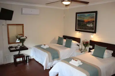 a hotel room with two beds and a mirror at Ngwenya Boutique Hotel in Lephalale