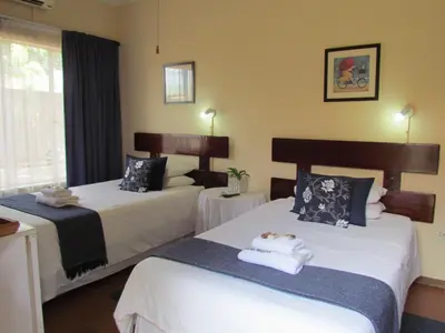 a hotel room with two beds and a window at Ngwenya Boutique Hotel in Lephalale
