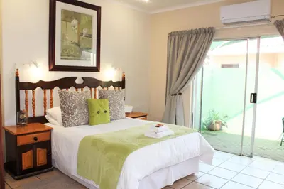 a bedroom with a bed and a sliding glass door at Ngwenya Boutique Hotel in Lephalale