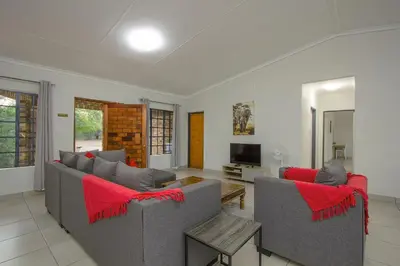 a living room with two couches and a tv at Shades of Nature in Marloth Park
