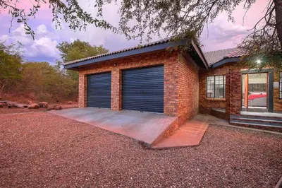 a brick house with two garage doors at Shades of Nature in Marloth Park