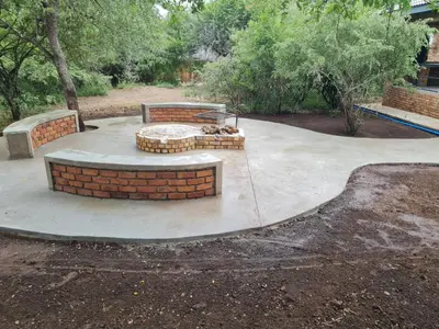 a circular concrete patio with a bench and a bench at Shades of Nature in Marloth Park