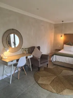 a bedroom with a bed and a desk and a mirror at Annie’s Place Self Catering 2 in Kempton Park