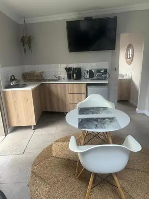 a kitchen with a white table and a white chair at Annie’s Place Self Catering 2 in Kempton Park