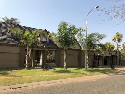 a house with palm trees and a street light at Annie’s Place Self Catering 2 in Kempton Park