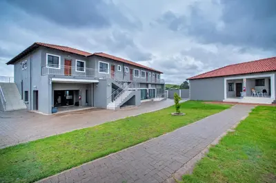 a large building with a grassy yard in front of it at Khayalami Hotel - Emalahleni in Witbank