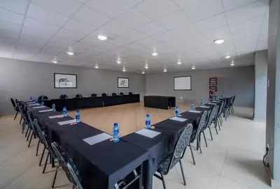 a large room with tables and chairs in it at Khayalami Hotel - Emalahleni in Witbank