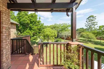 a patio with a deck with a fence and trees at Greenway Woods Chalet in White River