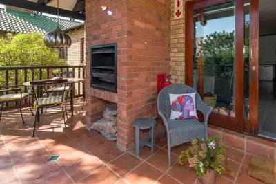 a brick fireplace on a patio with a table and chairs at Greenway Woods Chalet in White River