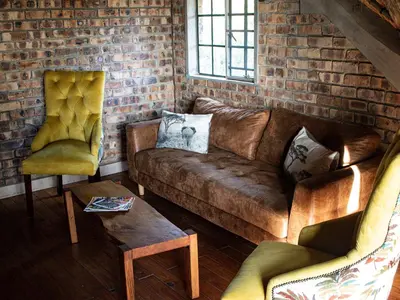 a living room with a couch and two chairs at Injabulo in Marloth Park