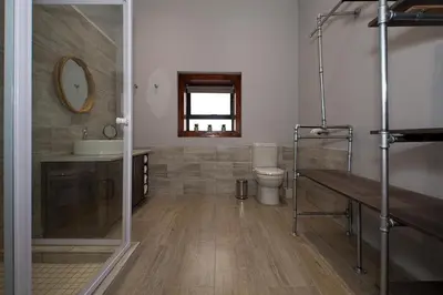 a bathroom with a toilet and a sink and a mirror at Merino Stal Guest Farm in Ermelo