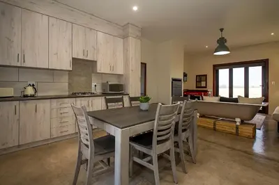 a kitchen and dining room with a table and chairs at Merino Stal Guest Farm in Ermelo