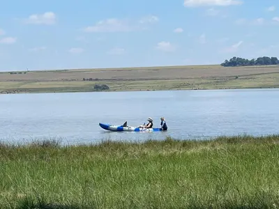 two people are in a boat on a lake at Merino Stal Guest Farm in Ermelo