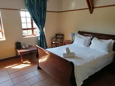 a bedroom with a bed with a stuffed animal on it at The Woodsman Bed and Breakfast in Sabie