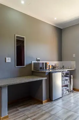 a kitchen with a counter with a microwave and a refrigerator at The Woodsman Bed and Breakfast in Sabie