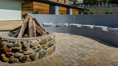 a stone fire pit in front of a building at The Woodsman Bed and Breakfast in Sabie